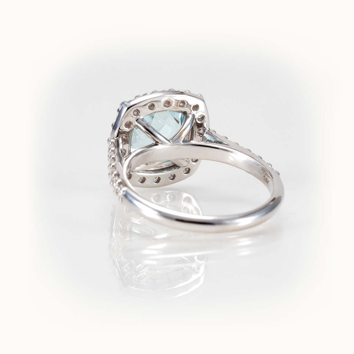 Back view of an elegant aquamarine ring with a diamond halo, showcasing its intricate design and luxurious setting.