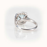 Back view of an elegant aquamarine ring with a diamond halo, showcasing its intricate design and luxurious setting.