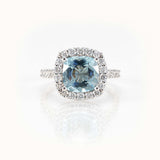 Elegant aquamarine ring featuring a cushion-cut gemstone and diamond halo set in 14 kt white gold.
