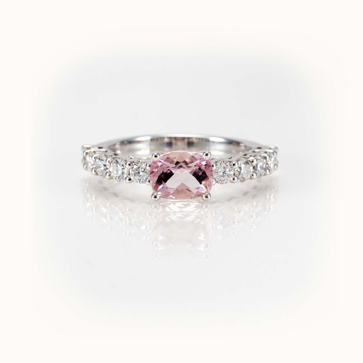 Elegant east-west morganite ring with diamond half-eternity band in 14kt white gold, showcasing a cushion-cut pink stone.