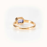 Elegant east-west light purple tanzanite ring in a sleek 14 kt yellow gold bezel setting.