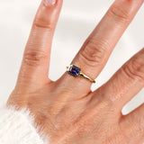 Elegant east-west light purple tanzanite ring in 14k yellow gold on a hand, showcasing its unique design.
