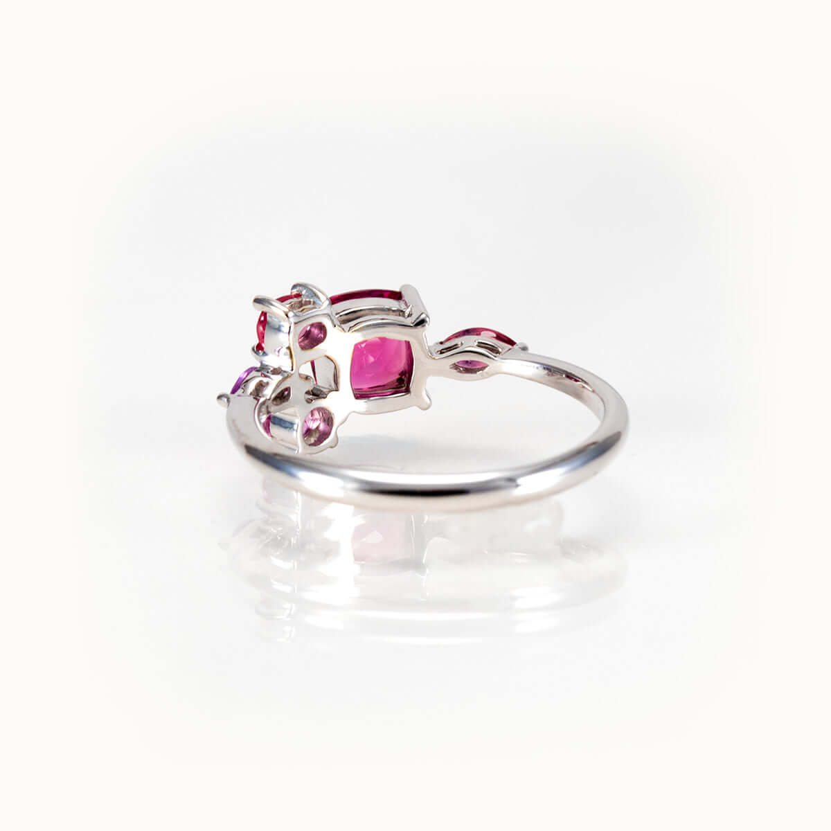 Elegant bespoke design ring featuring pinkish purple garnet and sapphire stones in 14kt white gold.