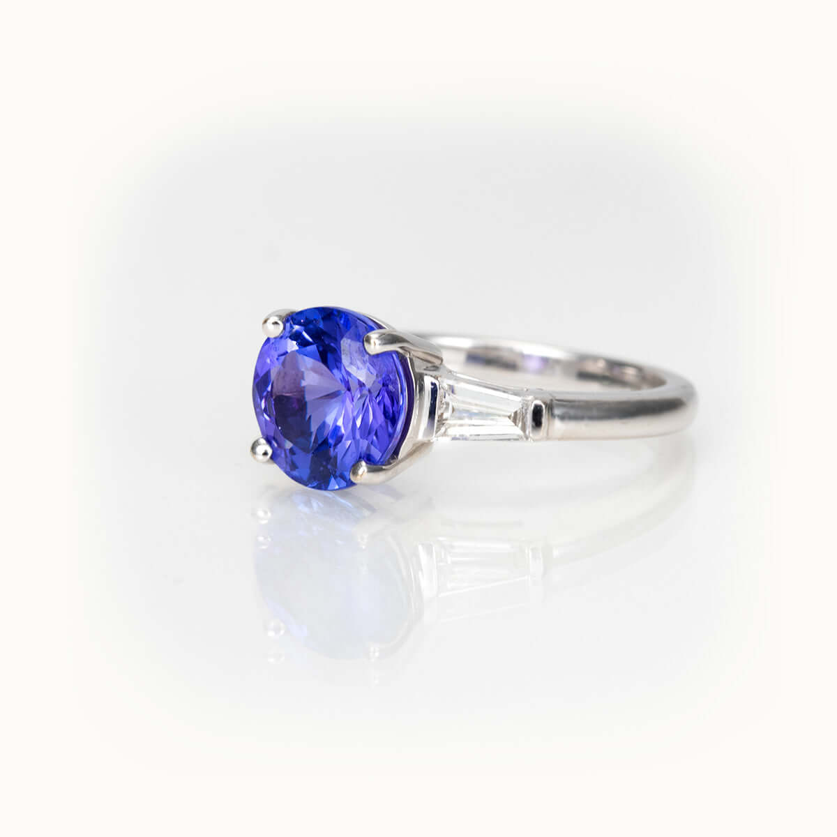 Tanzanite Elegance Ring in 14K white gold with vibrant violet-blue Tanzanite and baguette side stones.