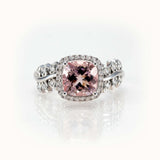 Pink morganite ring in 14K gold with diamond halo and leaf-inspired band, showcasing timeless elegance and bespoke design.