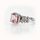 Elegant pink morganite ring with diamond halo and leaf-inspired band in white 14K gold, bespoke design.