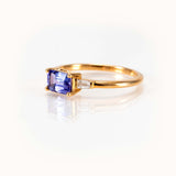 Elegant light blueish-purple tanzanite east-west ring with baguette diamonds in 14K yellow gold.