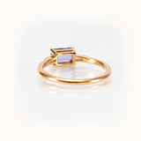 Light blueish-purple tanzanite east-west ring in 14K yellow gold, showcasing a bespoke and elegant gemstone design.